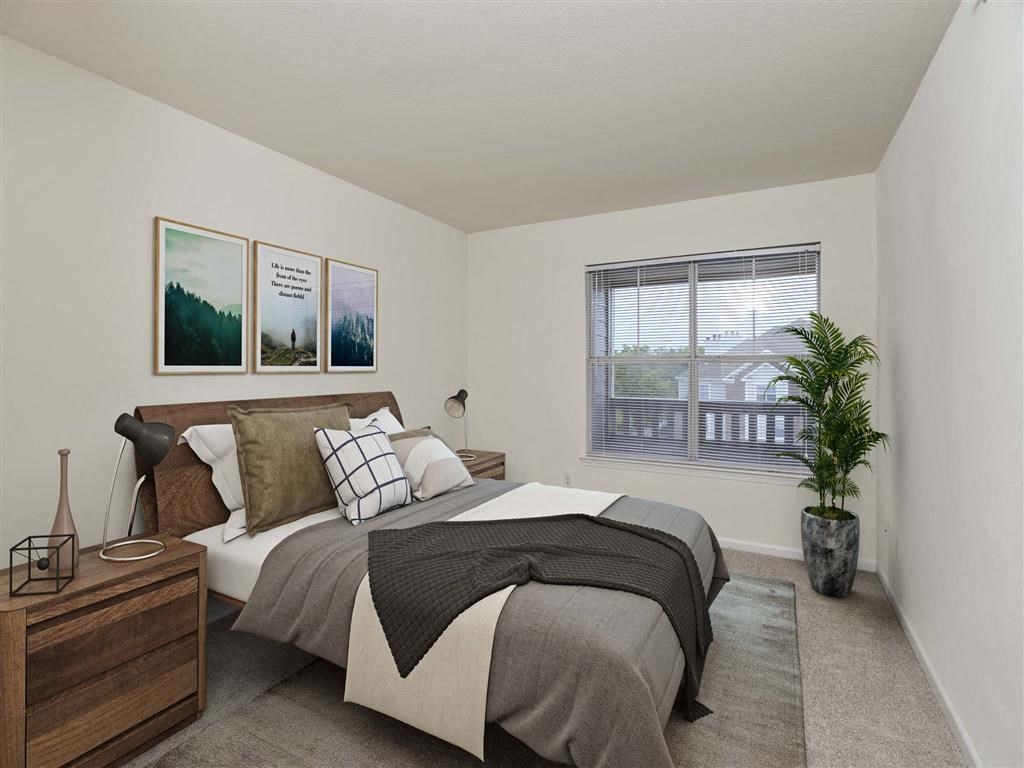 a bedroom with a large bed next to a window