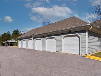 a row of three car garages with a carport in the background