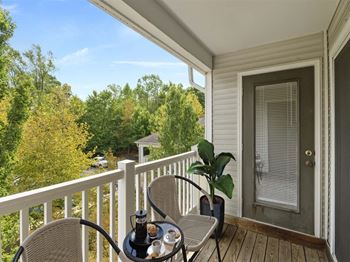 a porch with a table and chairs and a door with a window