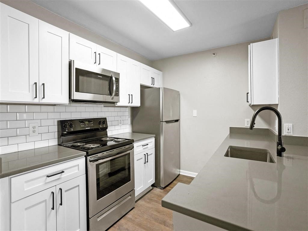 Updated kitchen with white cabinets and stainless steel appliances