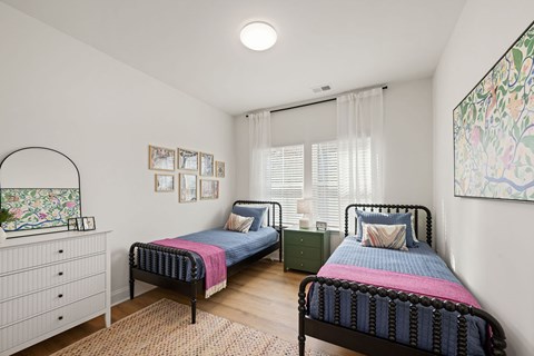 A bedroom with two beds and a dresser.