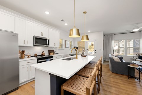 A modern kitchen with a large island and wooden chairs.