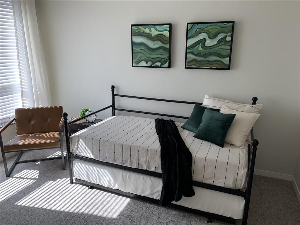 a bedroom with a bed and two paintings on the wall