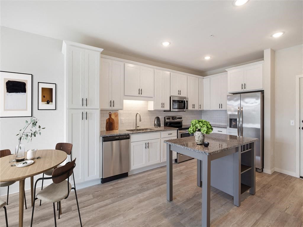 a kitchen with a center island and a stainless steel refrigerator