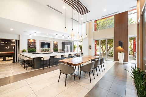 A modern dining room with a long table and chairs.