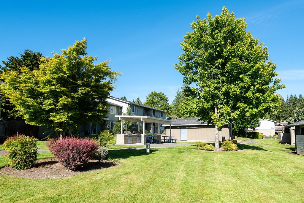 a house with a yard and trees in front of it
