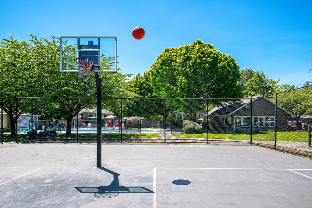 a basketball court with a basketball hoop and a ball in the air