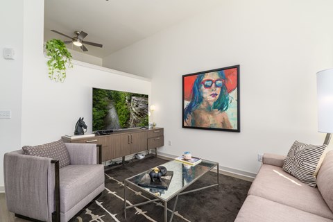A living room with a couch, chair, and a painting on the wall.