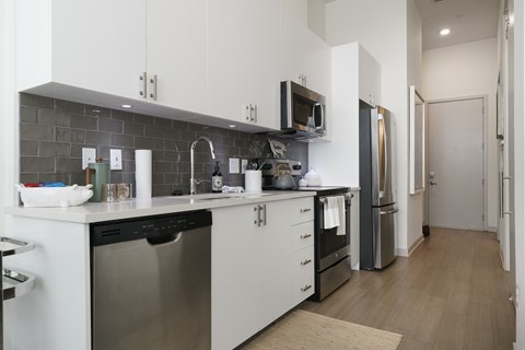A modern kitchen with white cabinets and stainless steel appliances.