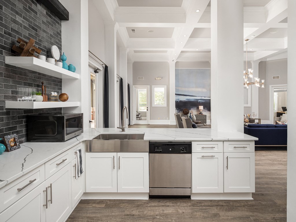 a kitchen with white cabinets and a stainless steel dishwasher