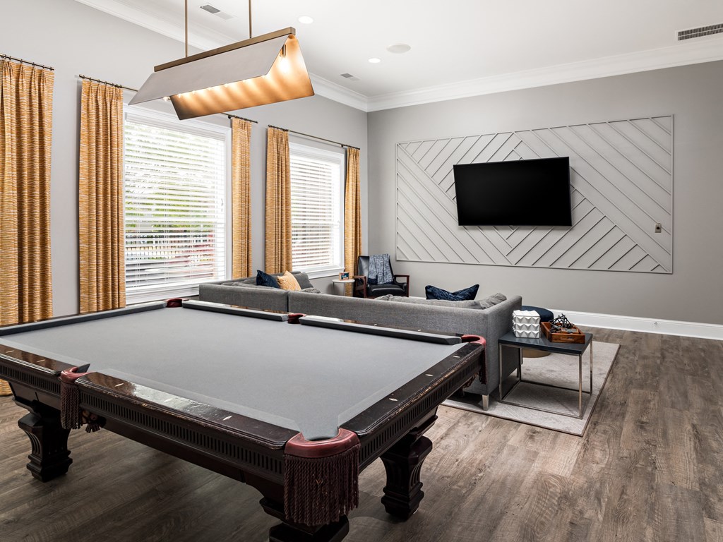 a living room with a pool table and a tv
