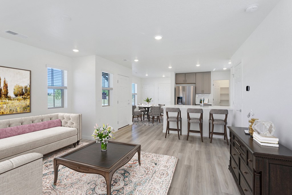 a living room with a couch and a coffee table in front of a kitchen