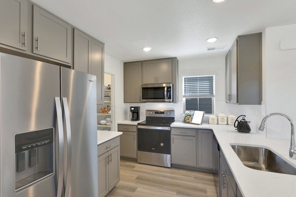 a kitchen with stainless steel appliances and white counter tops