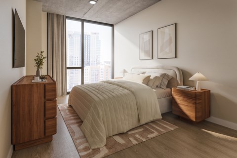 A bedroom with a large bed and a wooden nightstand.