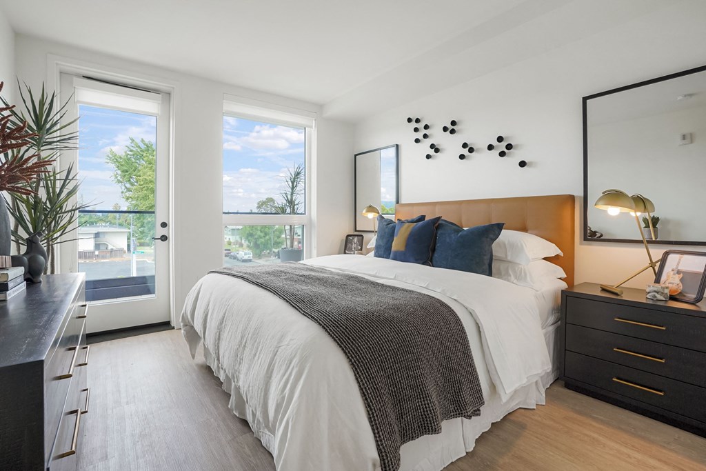 a bedroom with a large bed and two windows