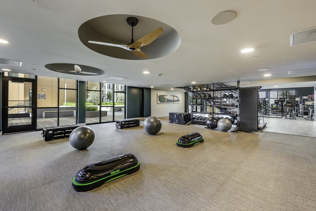 A room with a grey floor and a ceiling fan.