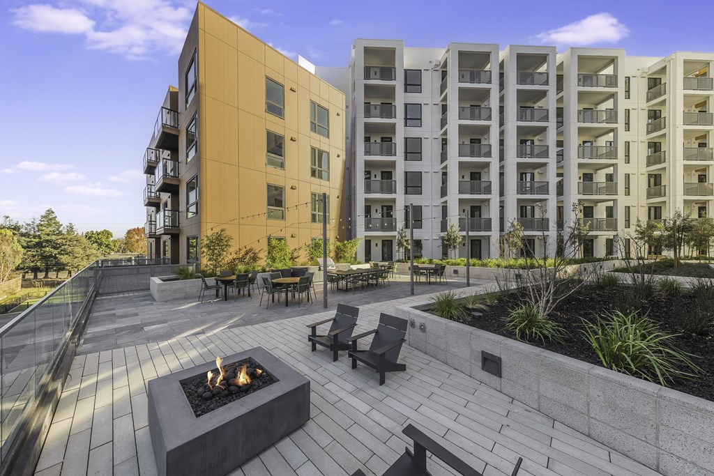 A modern building with a fire pit in the courtyard.