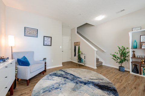 A living room with a white couch and a blue and white rug.