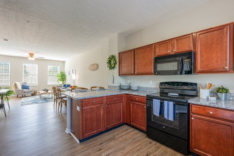 A kitchen with wooden cabinets and a black oven.