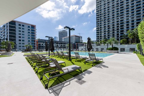 A poolside area with sun loungers and umbrellas.