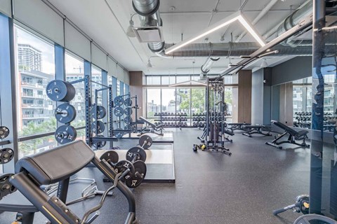 A gym with a variety of equipment including weights and machines.