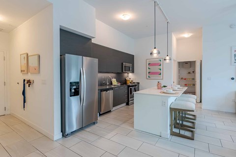 A modern kitchen with a stainless steel refrigerator and white countertops.
