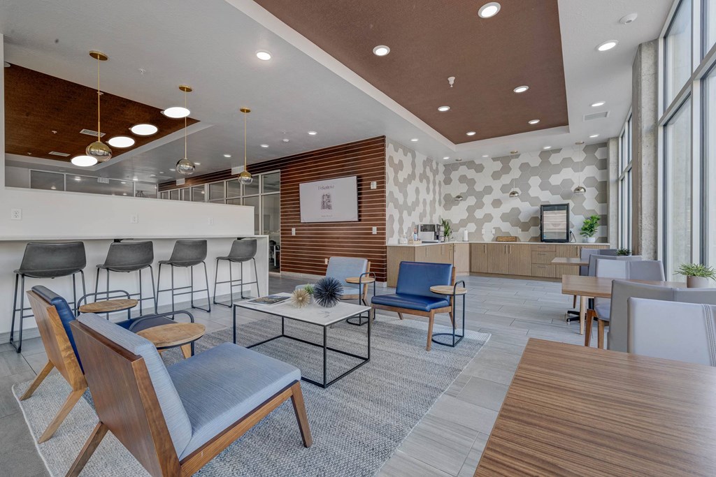 A modern waiting room with blue chairs and a wooden floor.