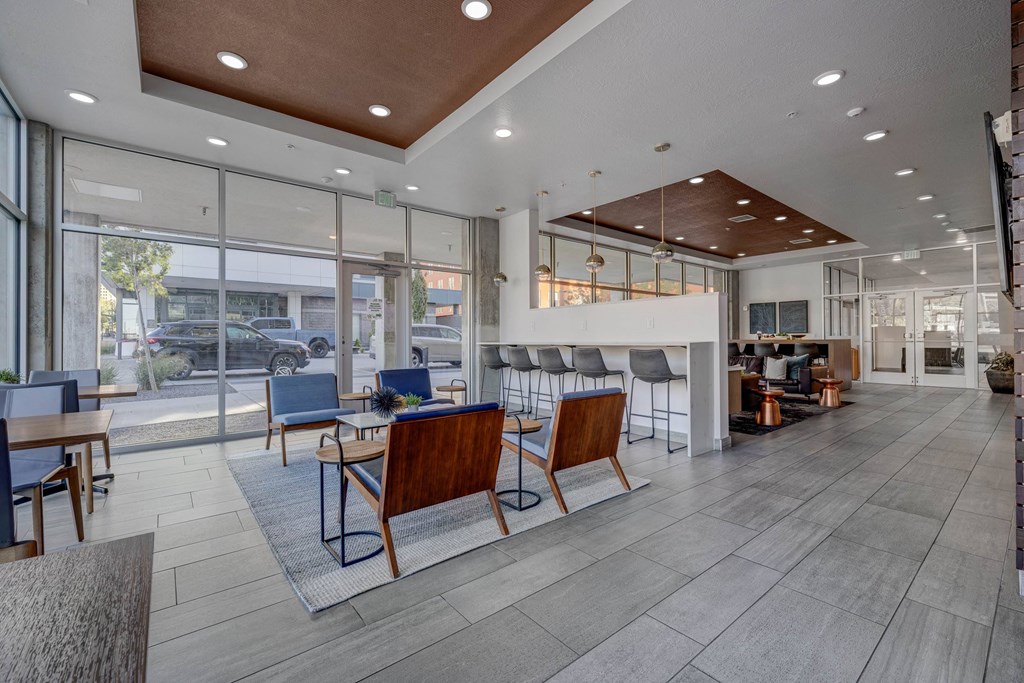 A spacious waiting area with wooden chairs and a glass wall overlooking the street.