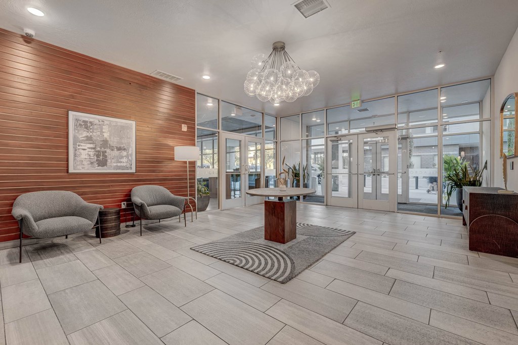 A modern waiting room with a wooden wall and a chandelier.