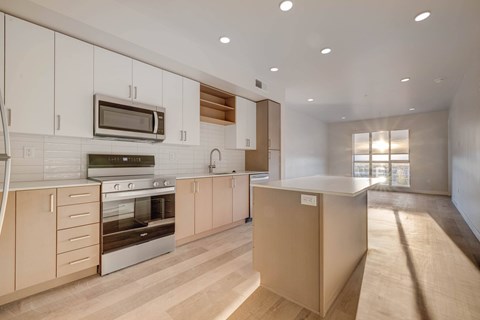 A modern kitchen with wooden cabinets and stainless steel appliances.