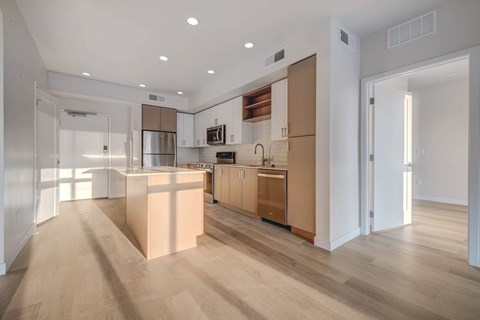 A modern kitchen with wooden floors and a central island.