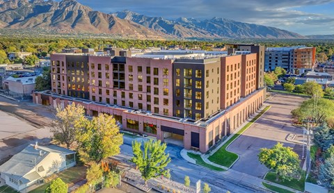 A large multi-story building with a parking lot in front of it.