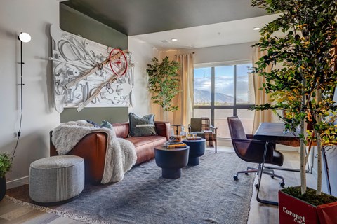 A living room with a large couch and a tree.