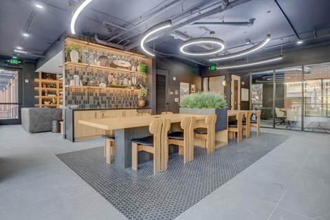 A modern dining area with wooden furniture and a wall of shelves with decorative items.