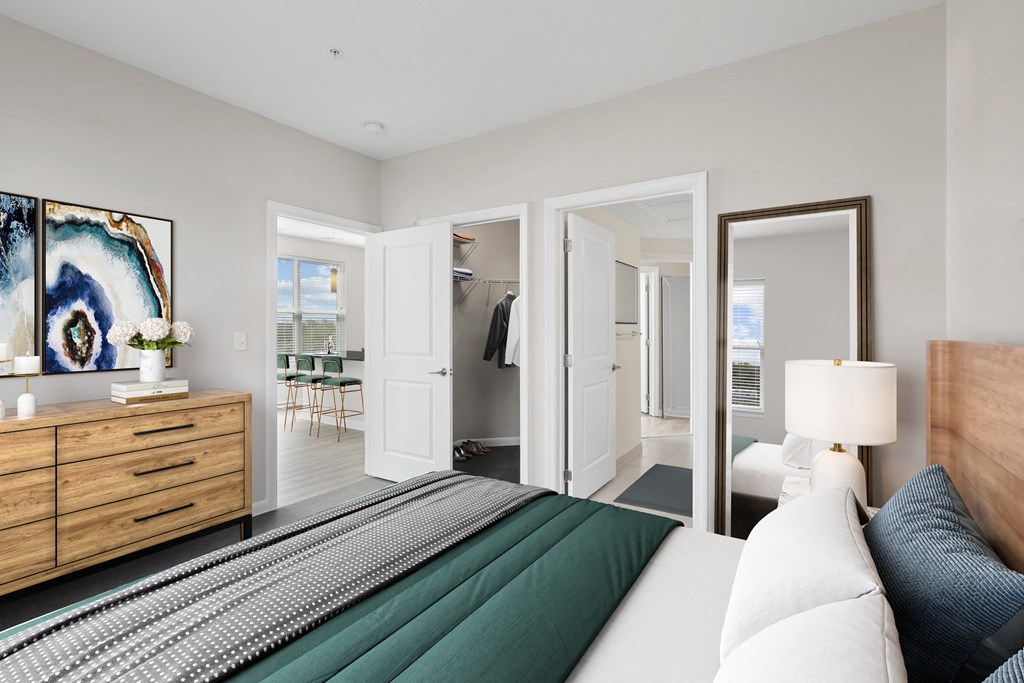 a bedroom with a large bed and a dresser with a mirror