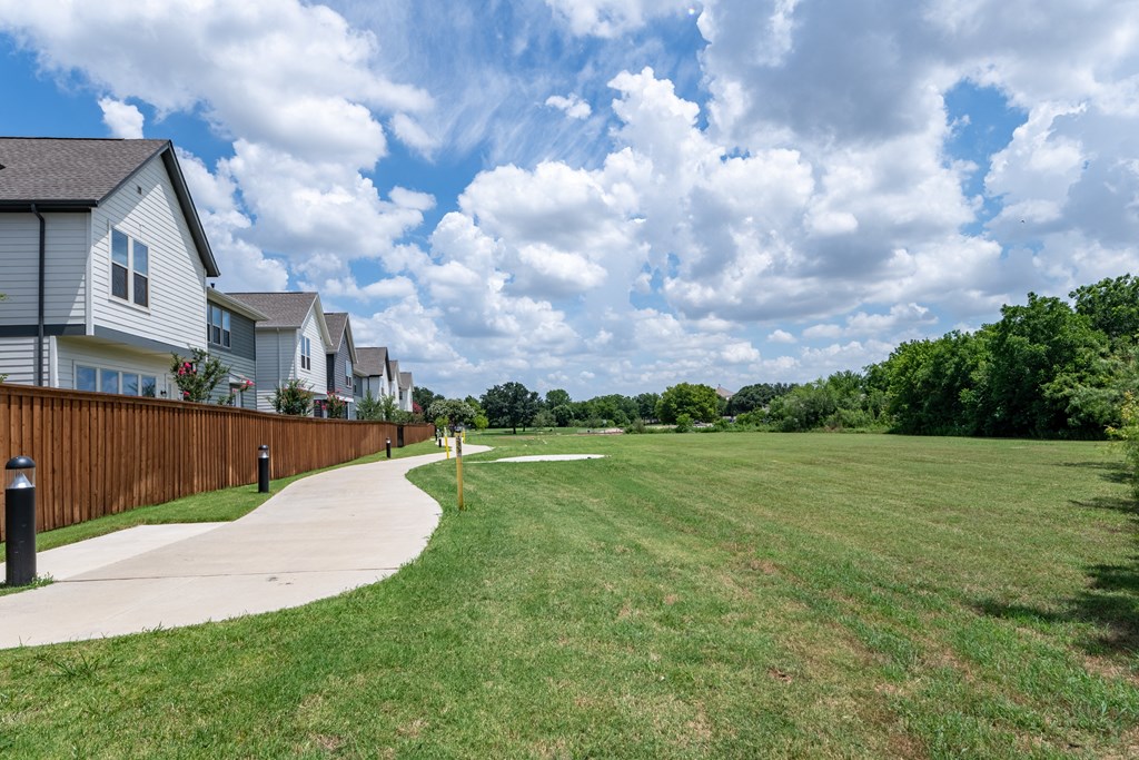 the yard of a house with a lawn and a sidewalk