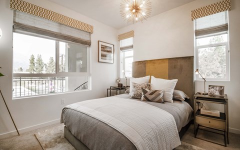 a bedroom with a bed and two windows