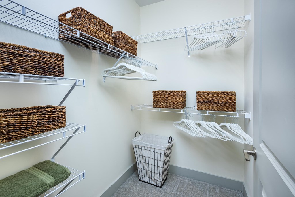 a closet with shelves and baskets and a basket in the corner