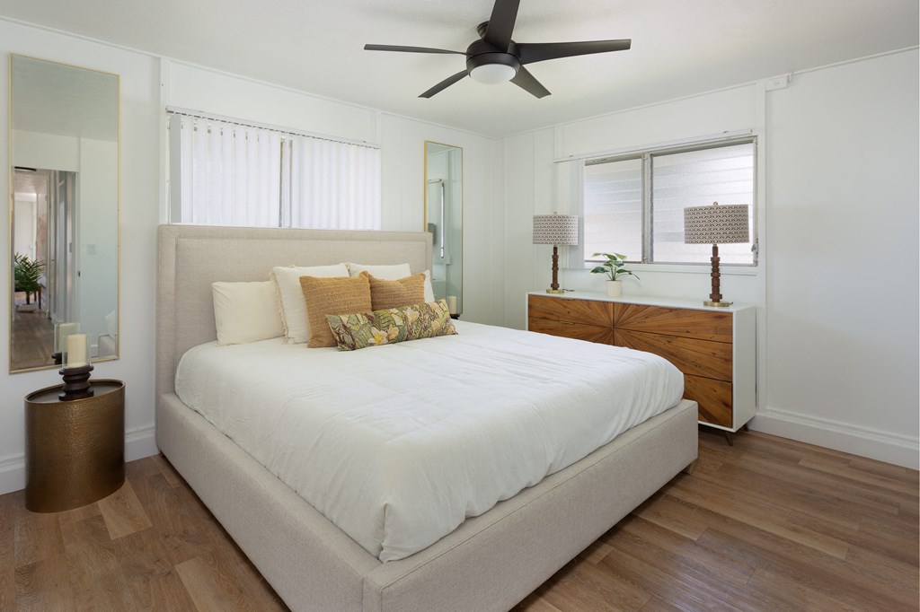 a bedroom with a large white bed and a ceiling fan