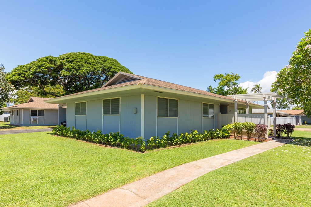 a blue house with a lawn and a sidewalk