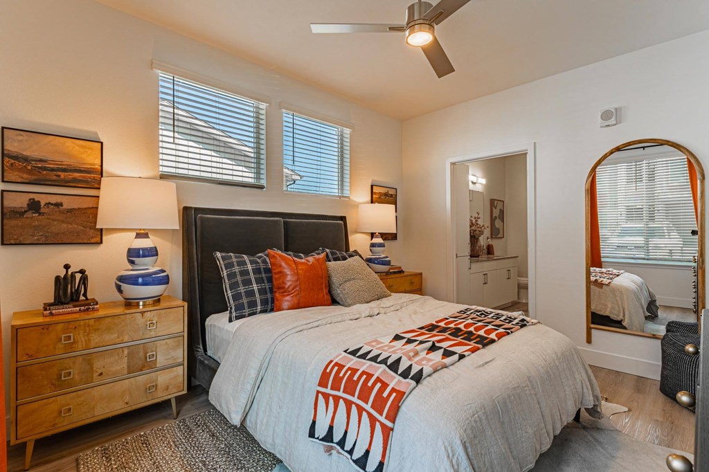 A bedroom with a bed, dresser, and mirror.
