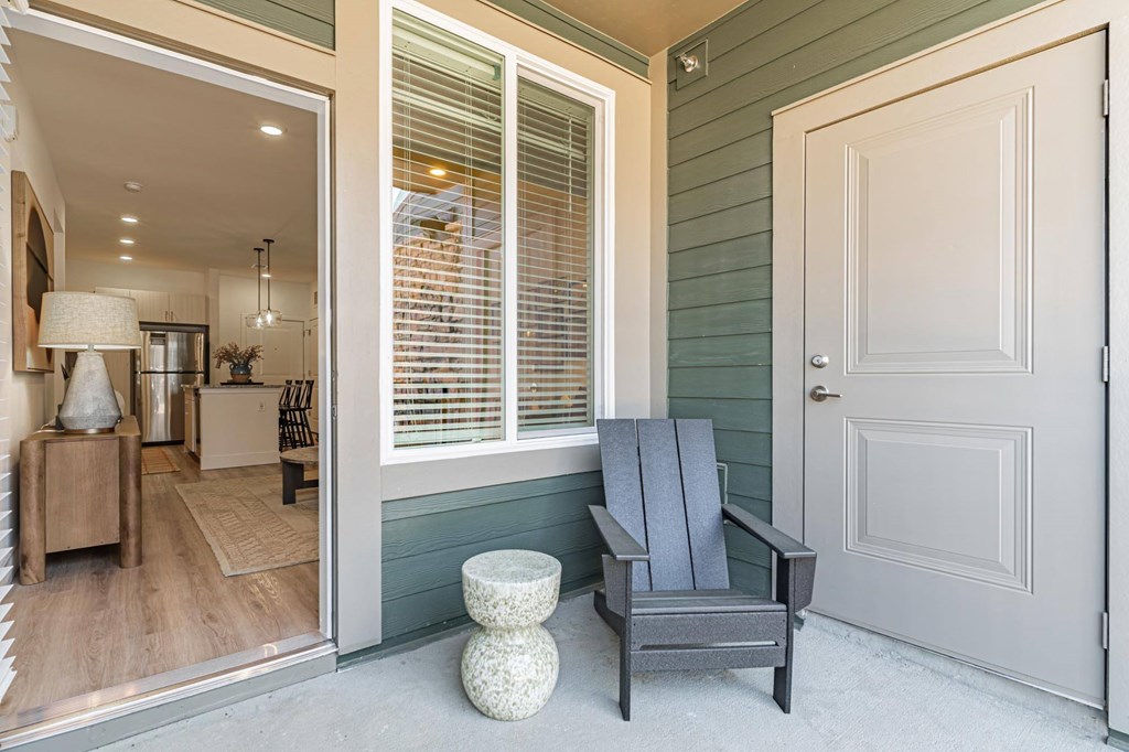 A grey chair is in front of a white door.