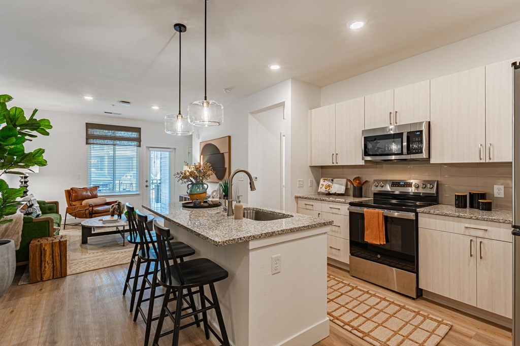 A kitchen with a white countertop and black bar stools.