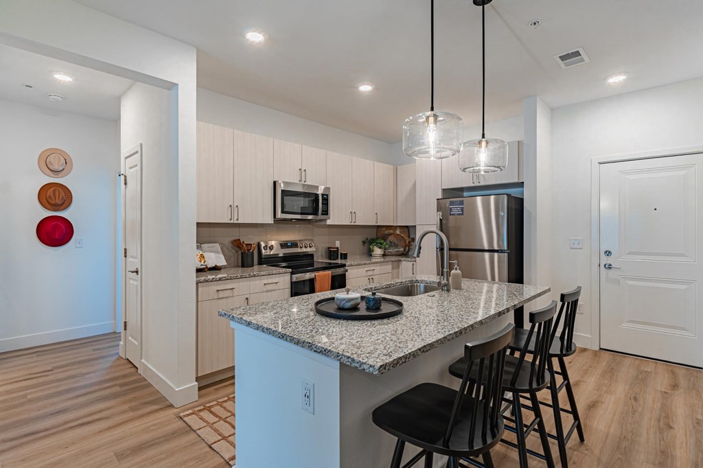 A kitchen with a granite countertop and a refrigerator.