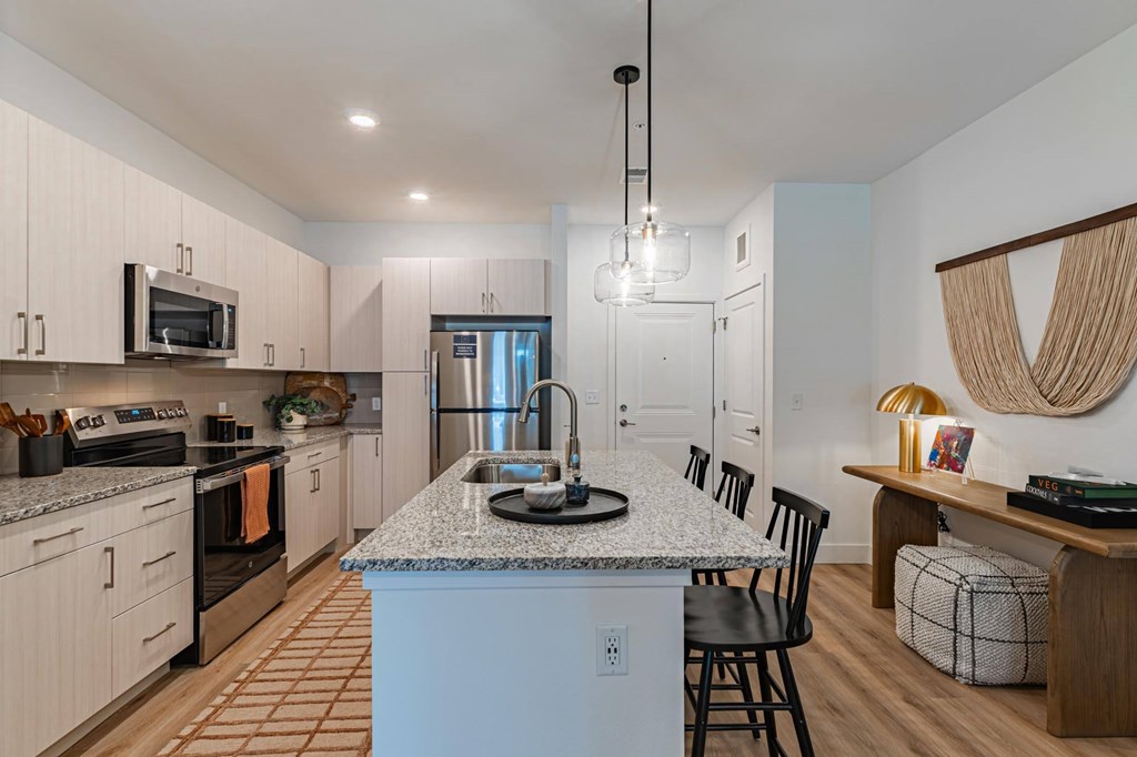 A kitchen with a granite countertop and a dining area with a bench.