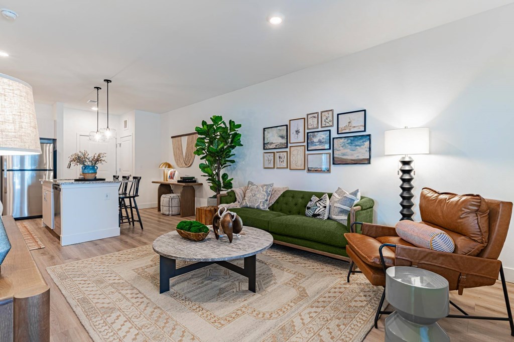 A living room with a green couch, a coffee table, and pictures on the wall.