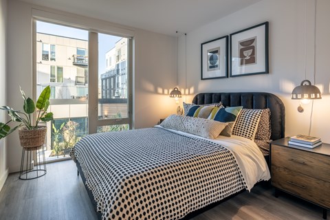 A bedroom with a large bed and a view of the city.