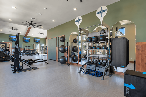 A gym with a variety of equipment including weights and a treadmill.