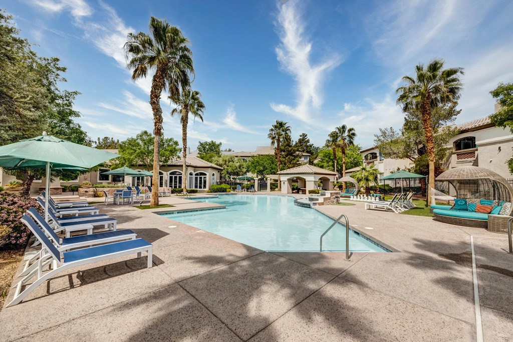 a swimming pool with lounge chairs and umbrellas