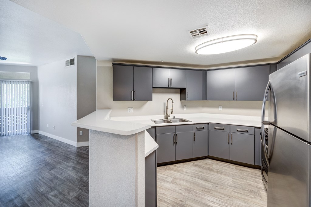 a kitchen with gray cabinets and a white counter top